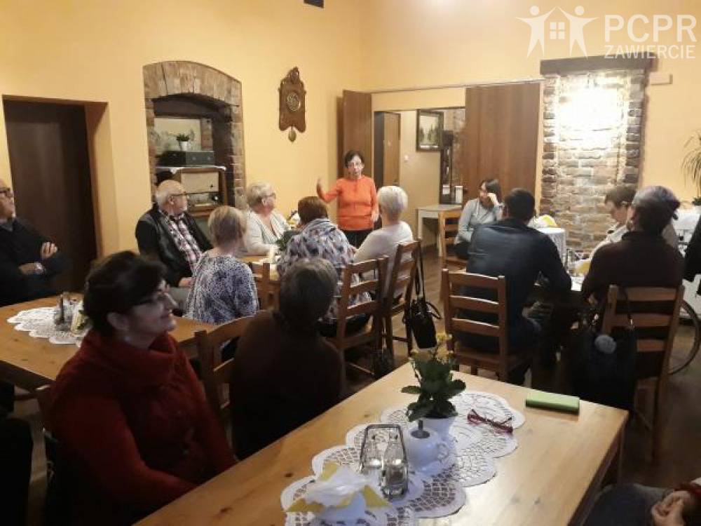 Zdjęcie: Grupa kobiet i mężczyzn siedząc przy stołach słucha prelekcji